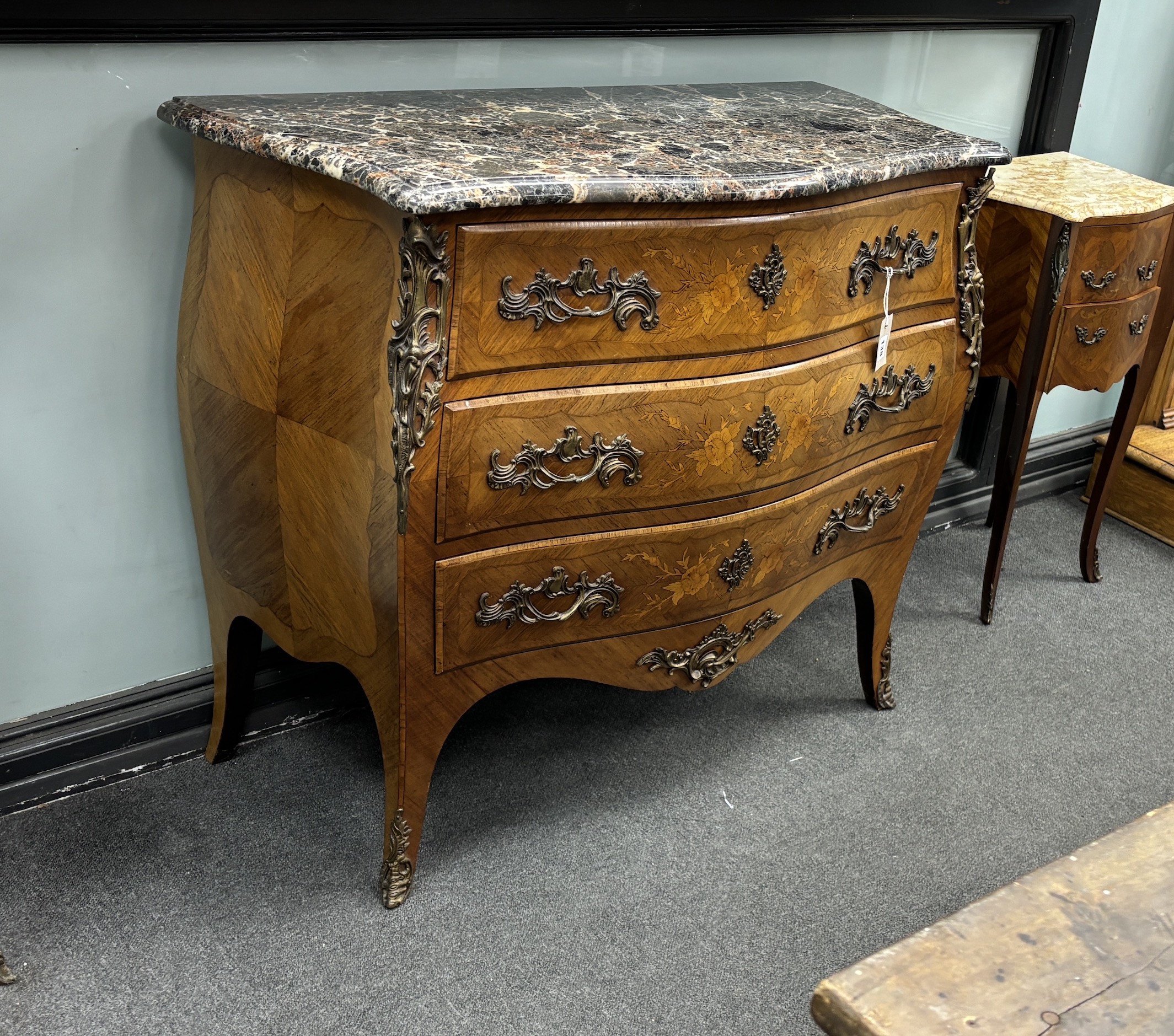 A Louis XVI style gilt metal mounted inlaid kingwood marble topped serpentine bombe commode, width 106cm, depth 49cm, height 89cm